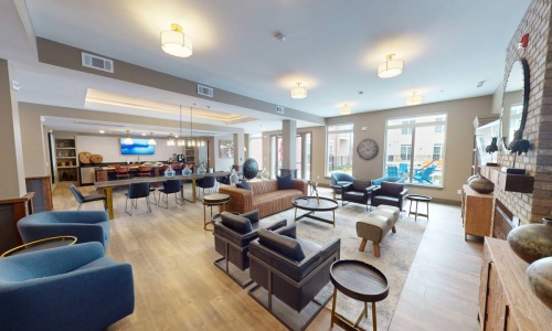 a clubroom with a couch, tables and chairs