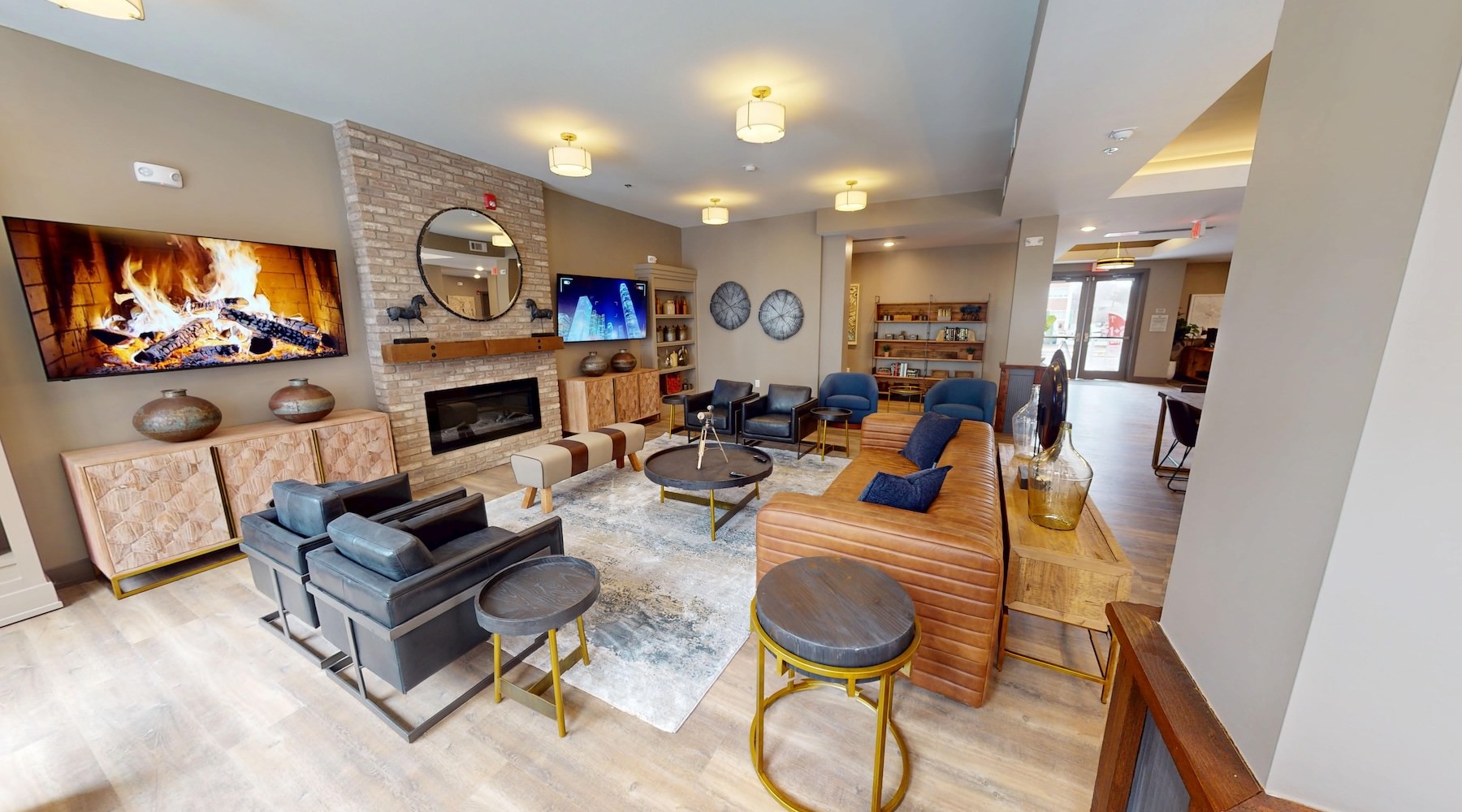 a clubroom with a tv, couch, chairs and tables