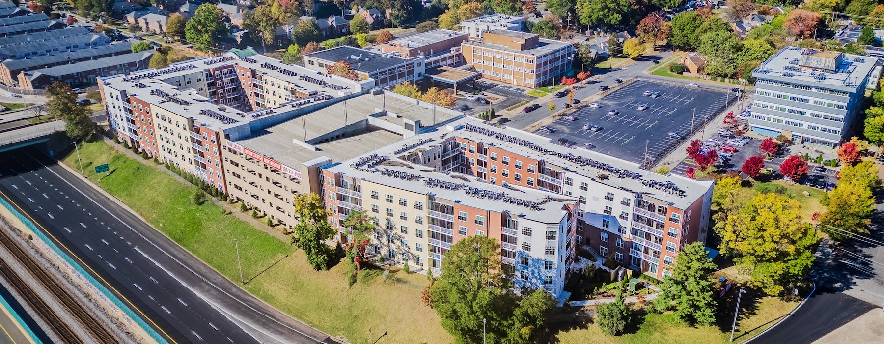 a large building with a road and trees around it