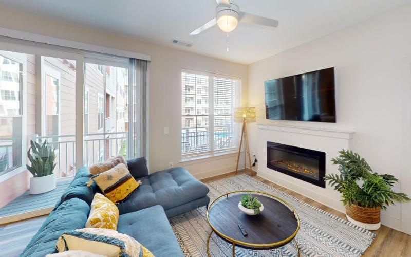 a living room with a fireplace, couch and a tv